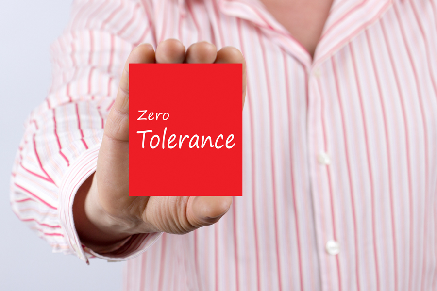 Person holding sign that reads 'zero tolerance'