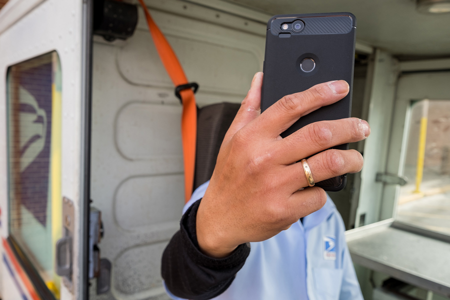 Employee holding cell phone inside a LLV