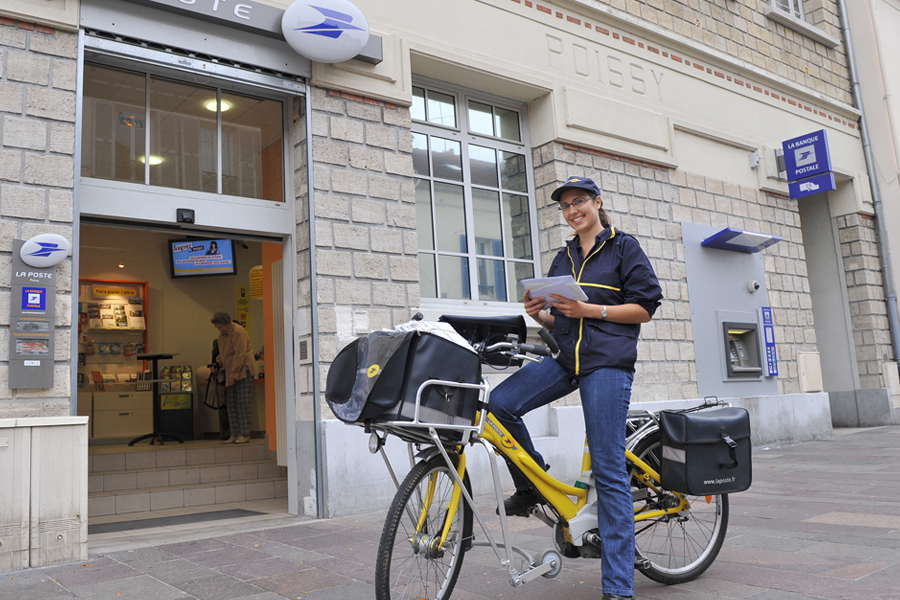 French letter carrier sits on bicycle