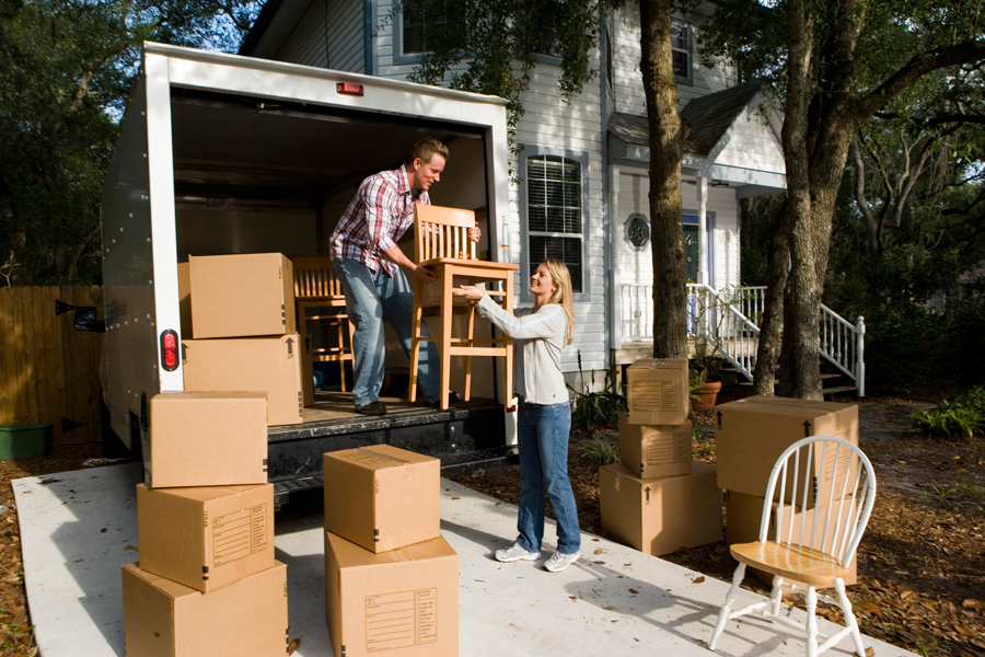 Man, woman carrying furniture out of moving van