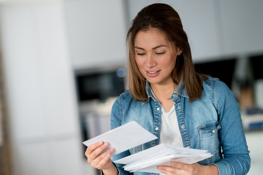 Woman looks at mail in kitchen