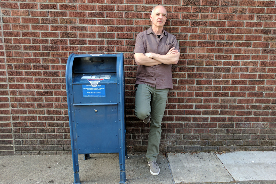 USPS customer stands next to blue box