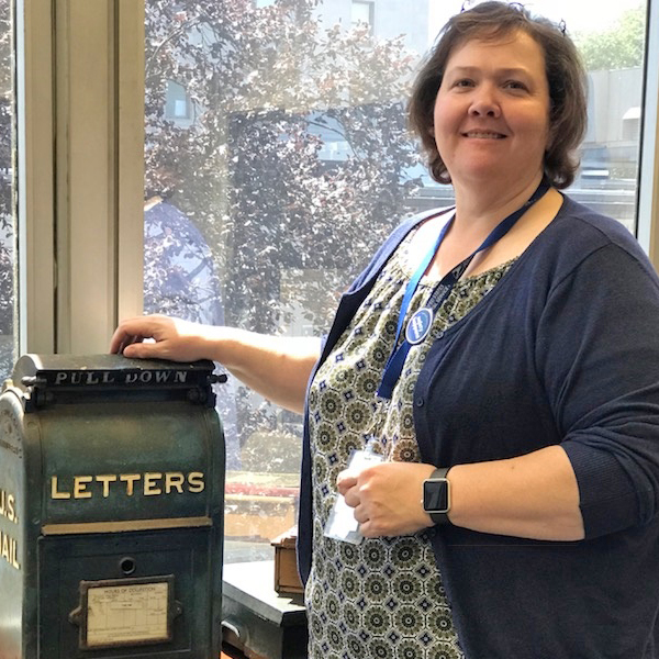 Administrative Assistant Rebecca Brundidge with vintage mailbox