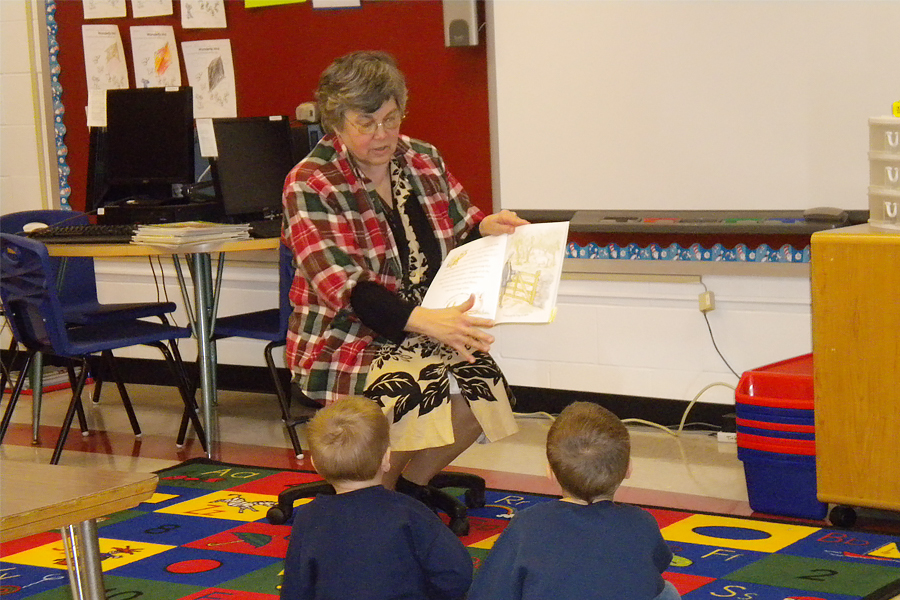 Woman reads to students