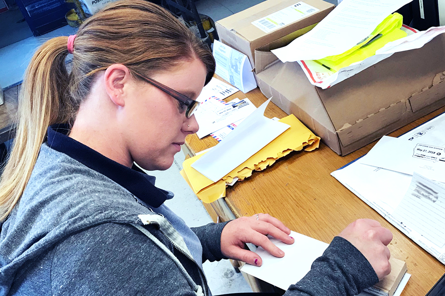 USPS employee applies a special postmark to mail