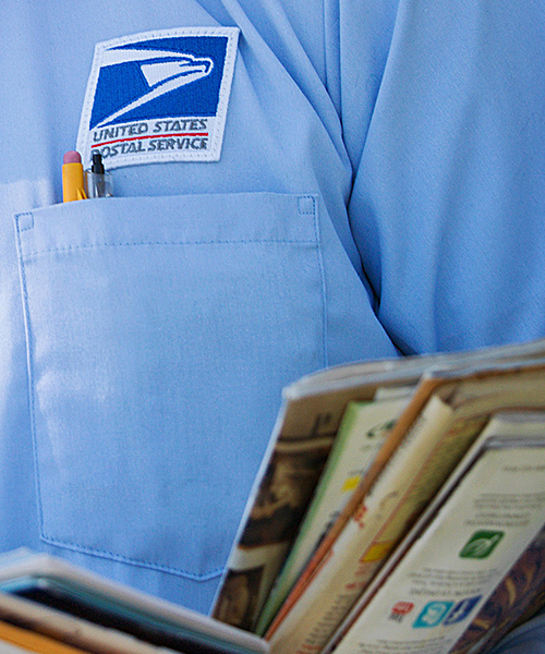 Close-up of letter carrier's hands holding mail