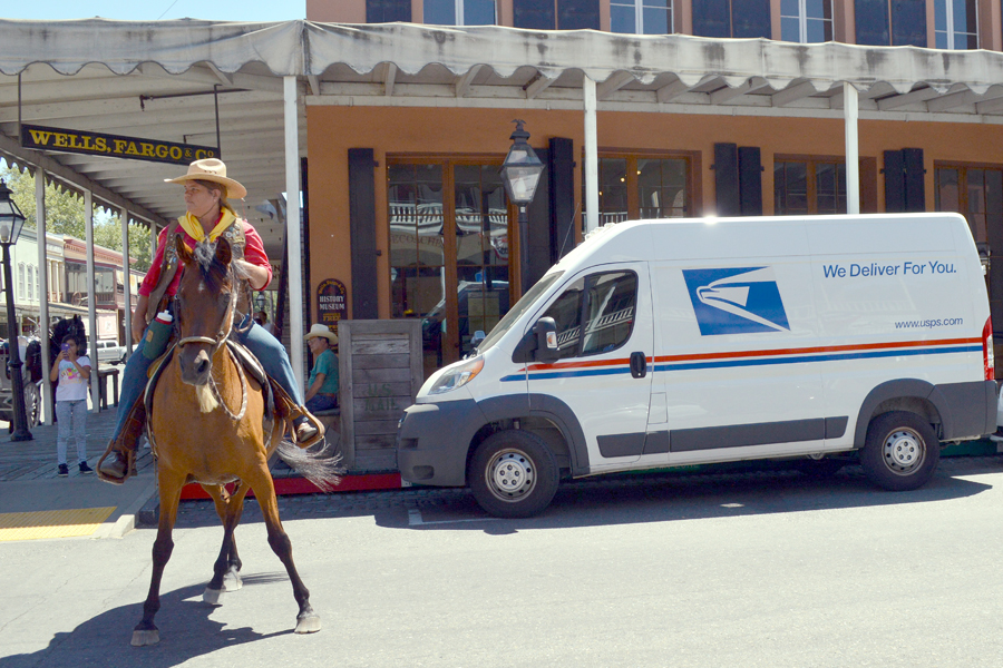 A USPS reenactor rides her horse