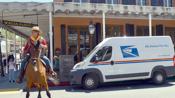 A USPS reenactor rides her horse