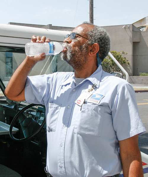 Postal worker drinks from water bottle