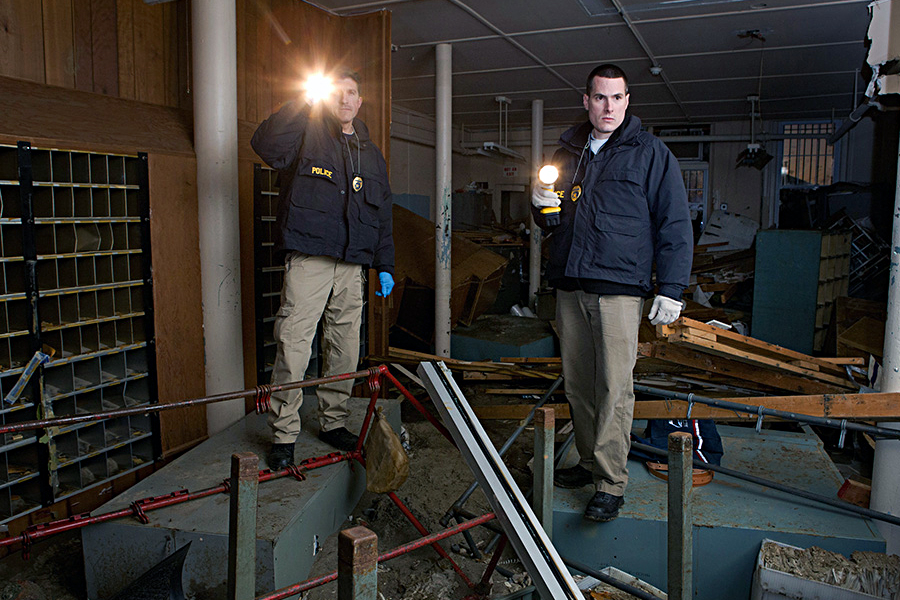 Two postal inspectors examine a workroom