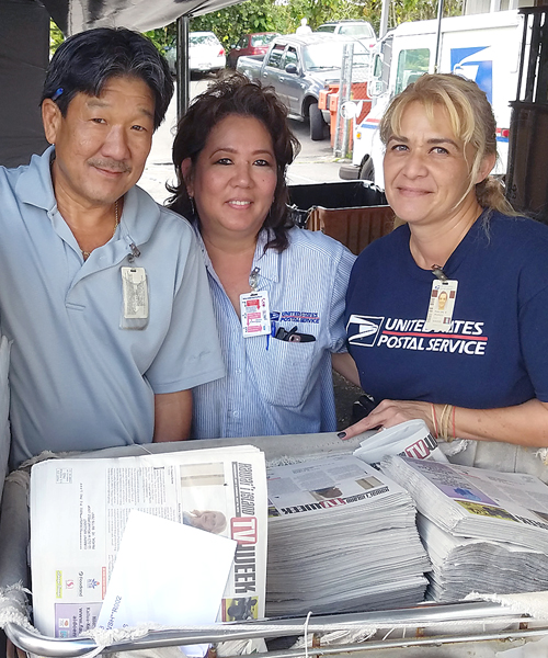 Three smiling postal workers