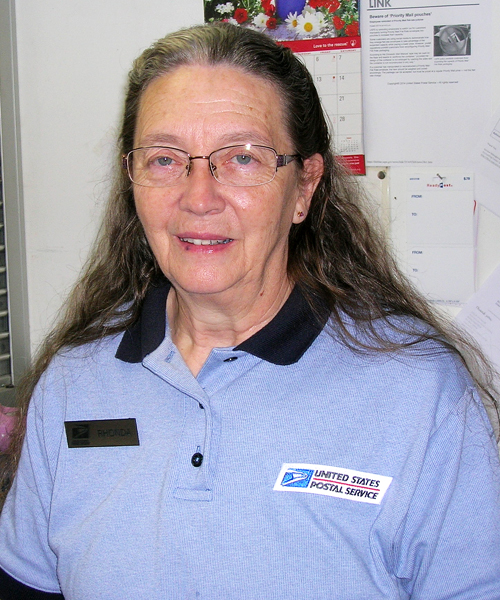 Smiling woman wearing postal uniform