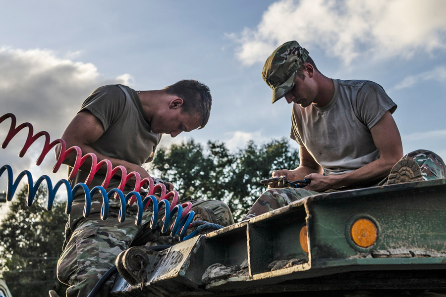 Army soldiers work on equipment