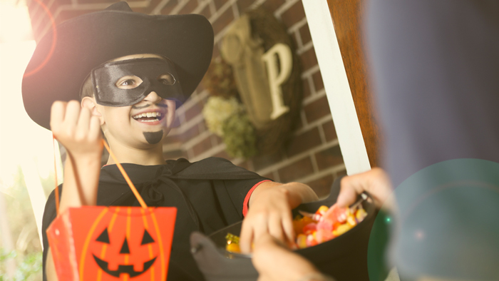 Child in Halloween costume with candy