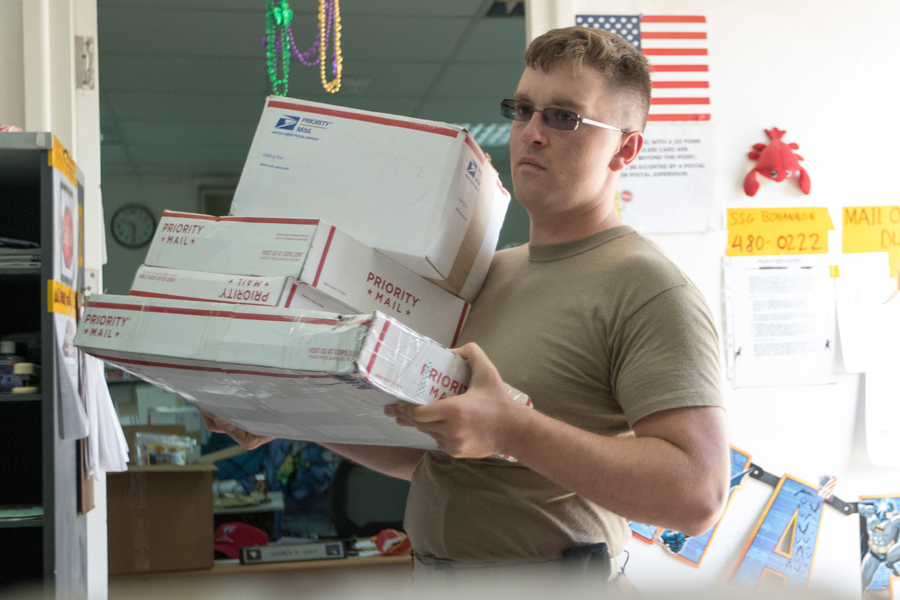 Soldier carries armful of Priority Mail packages