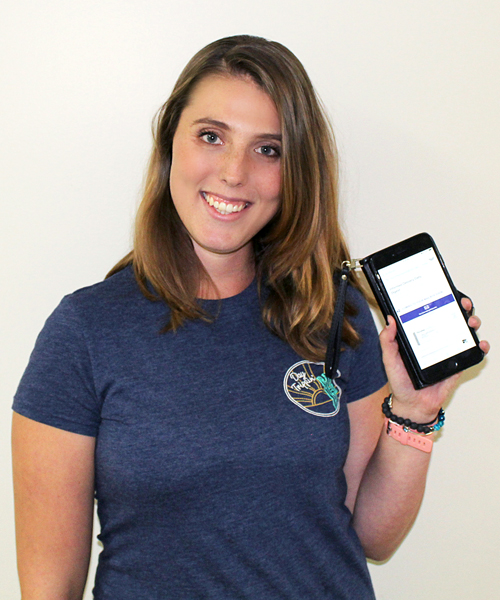 Smiling woman holds smartphone displaying Informed Delivery screen