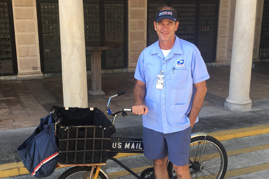 Letter carrier next to bicycle