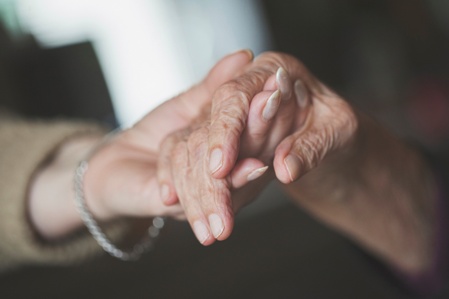 Hand of a younger person hold the hand of an older person