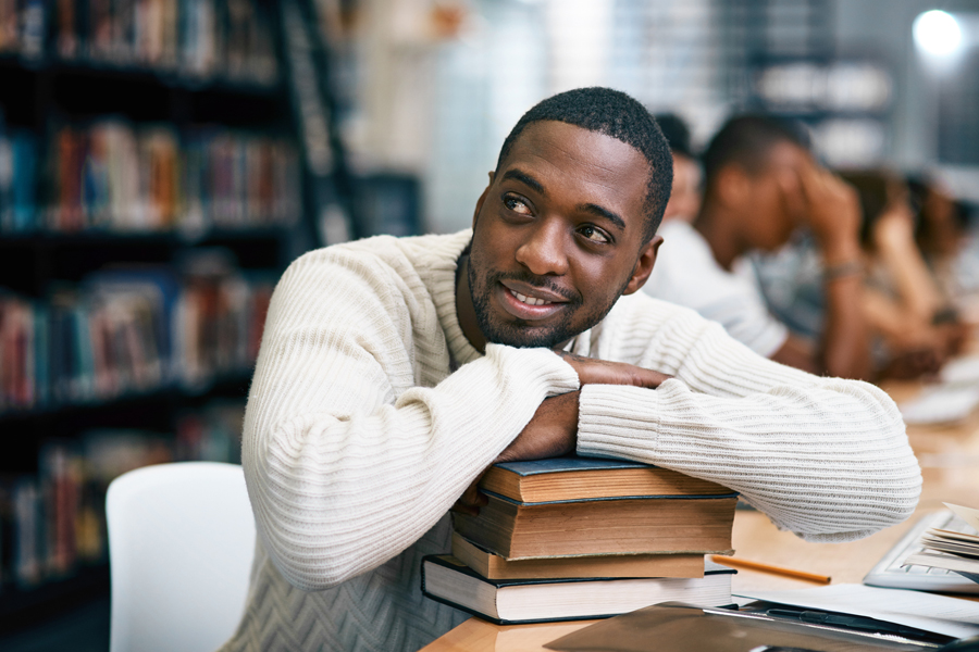 Smiling adult student sits in library
