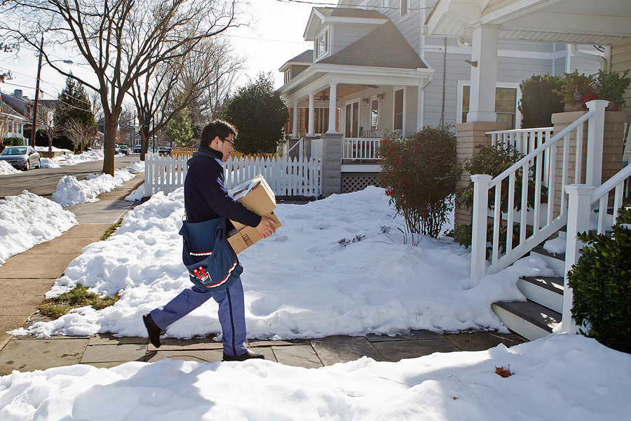 Letter carrier bringing packages to home