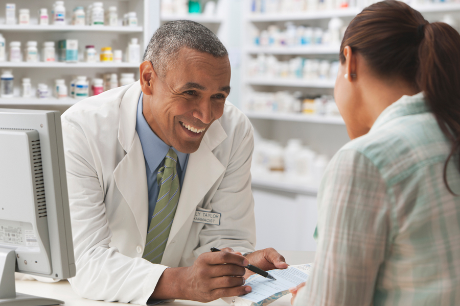 Smiling pharmacist serves customer