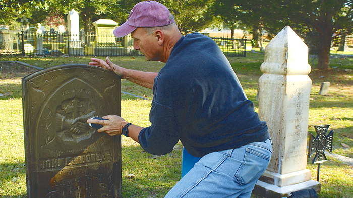 Postal employee cleans headstone