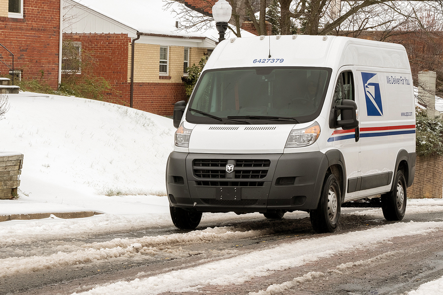 Postal delivery vehicle on snowy street