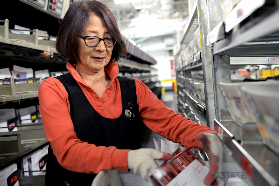 Woman sorts mail in postal plant