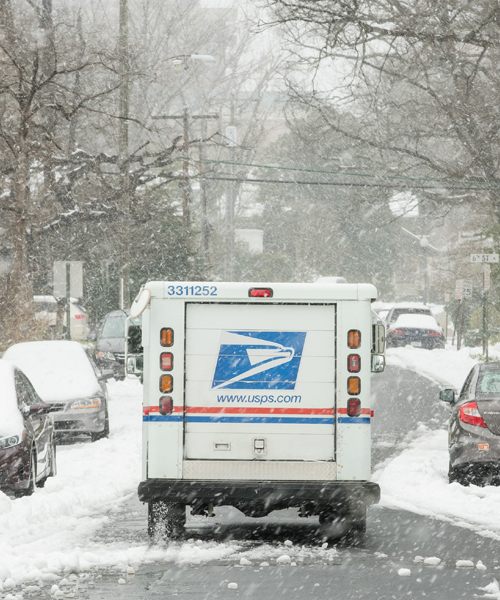 USPS delivery vehicle on snowy street
