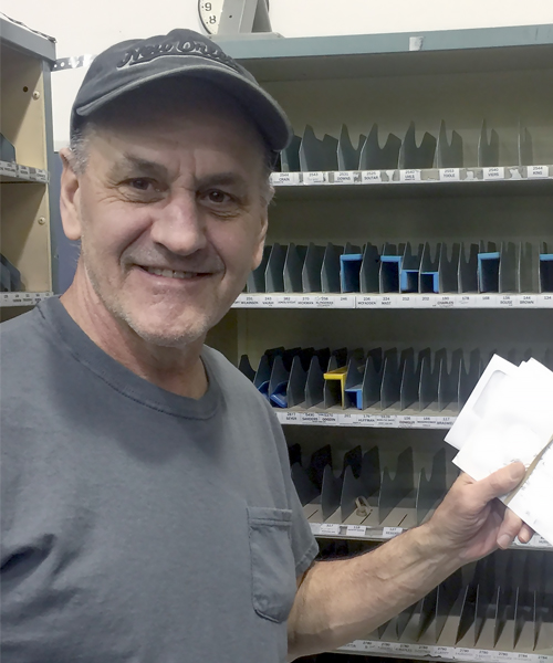 Postal Worker Rick Kay sorts mail