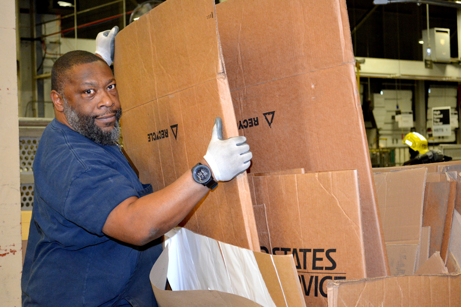 Postal worker handles cardboard