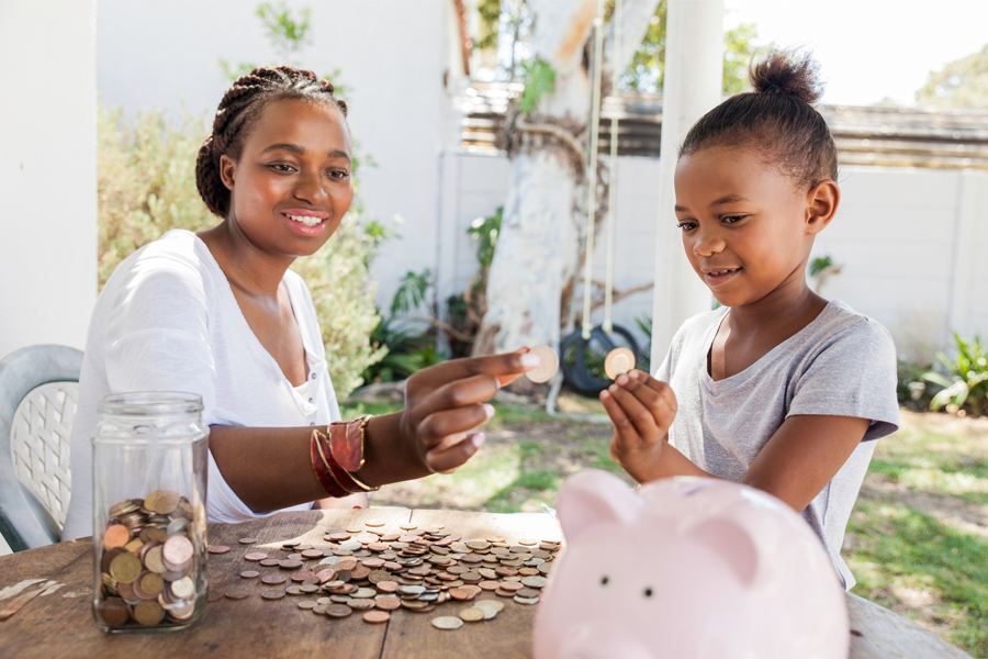 Woman and child place coins in piggybank