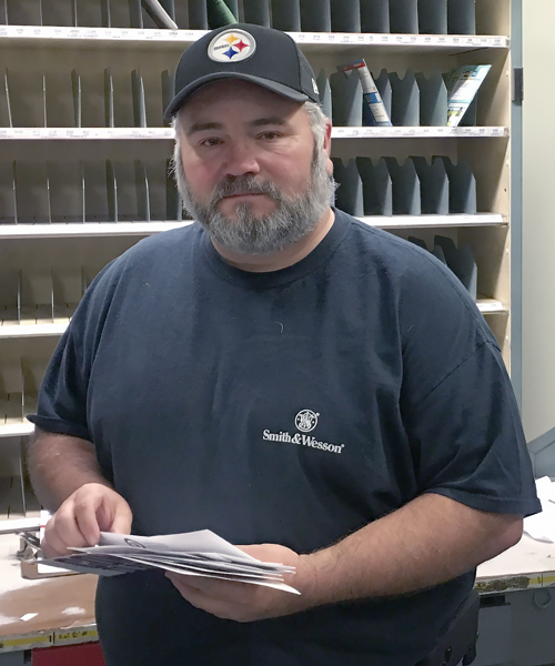 Worker holds mail in postal workroom