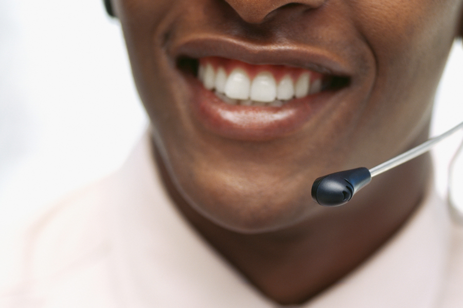 Smiling employee wearing a telephone headset.