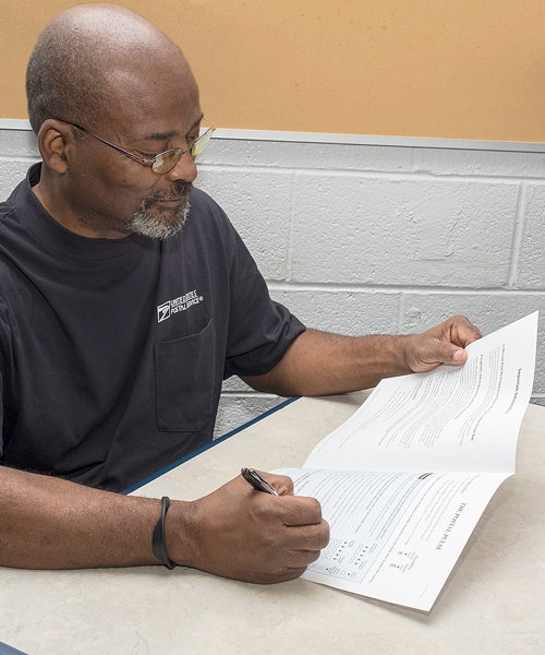 Man sitting at table, filling out form