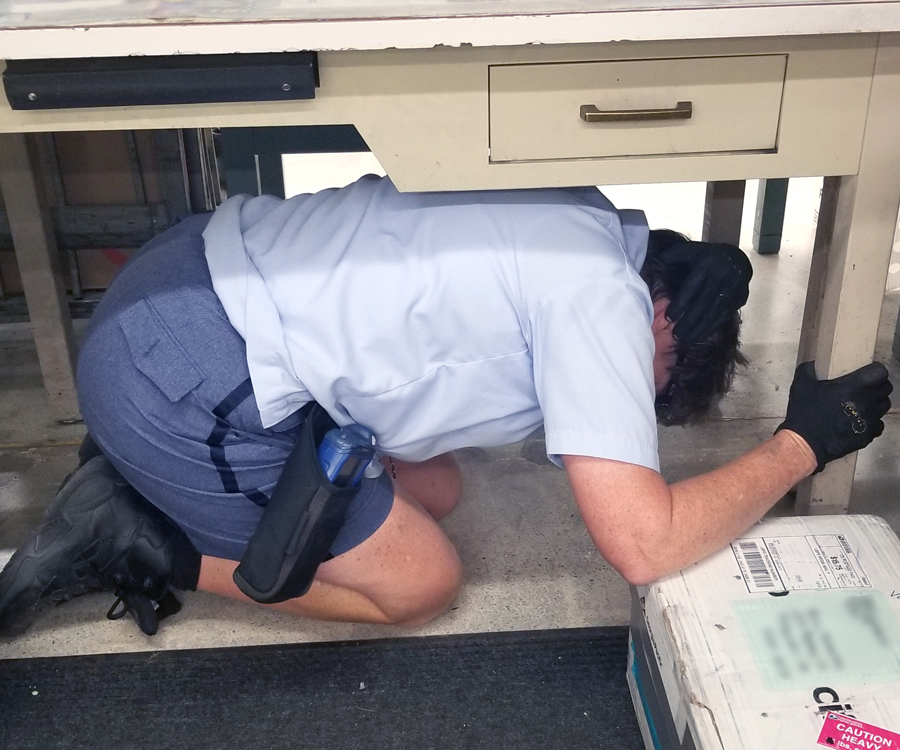 Postal worker crouches under desk