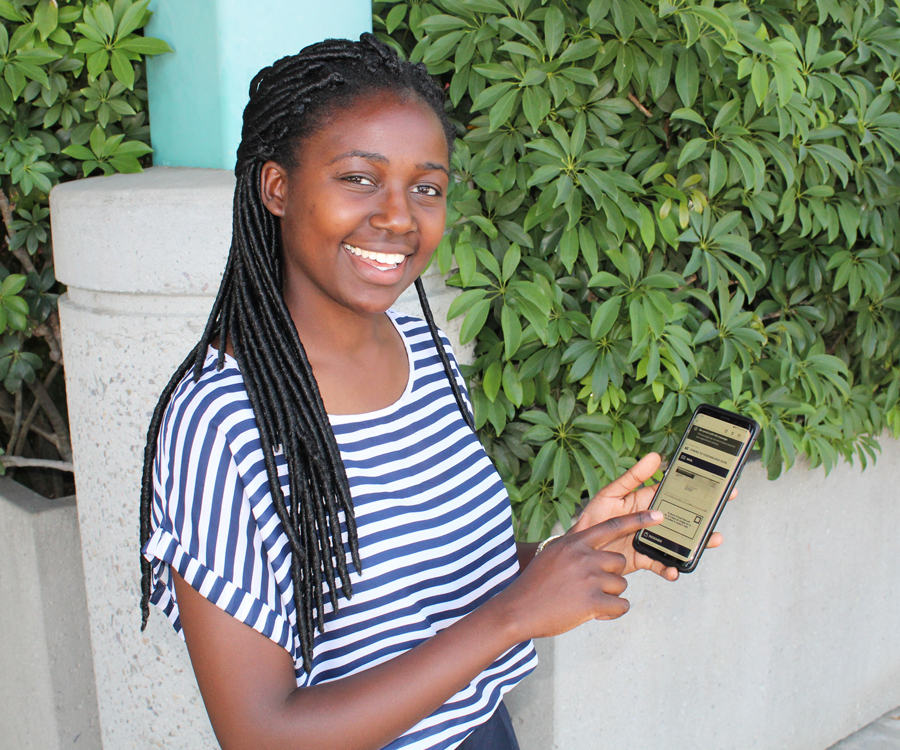 Smiling young woman holds smartphone displaying Informed Delivery message