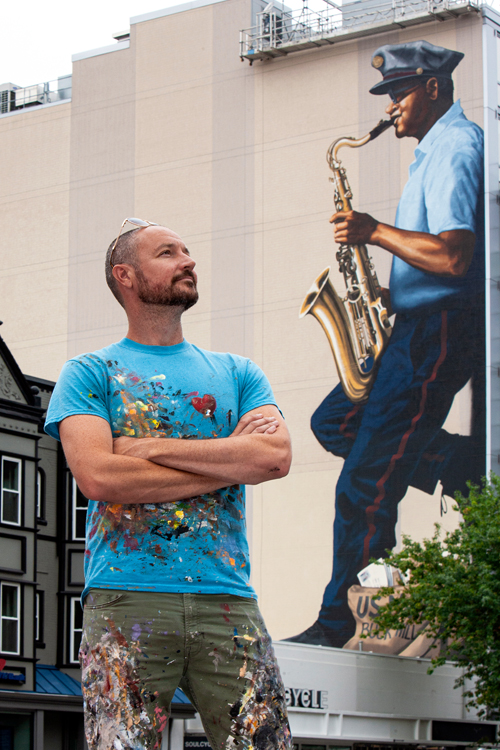 Man stands near mural