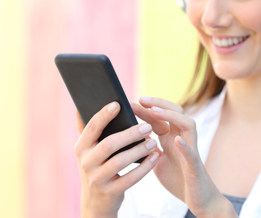Smiling woman touches keypad on smartphone
