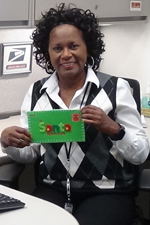 Postal employee holds holiday greeting card.