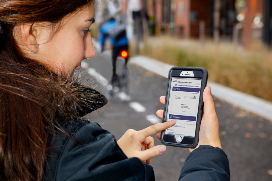 Woman looking at Informed Delivery display on smartphone screen