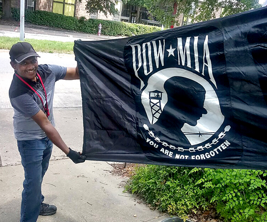 Man holds POW-MIA flag.