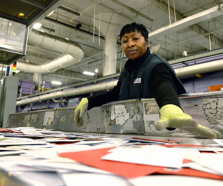 Worker sorts mail on postal workroom floor