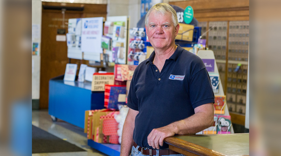 Smiling man stands in Post Office lobby