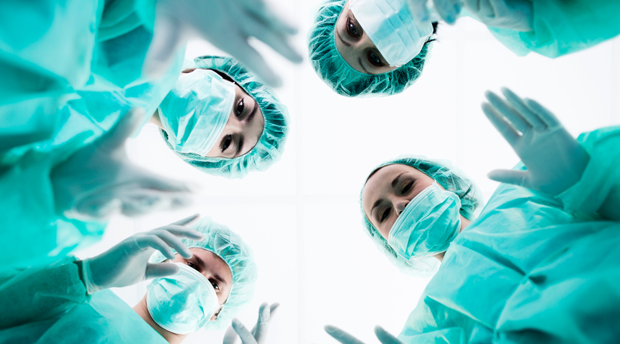 Four surgeons stand in operating room