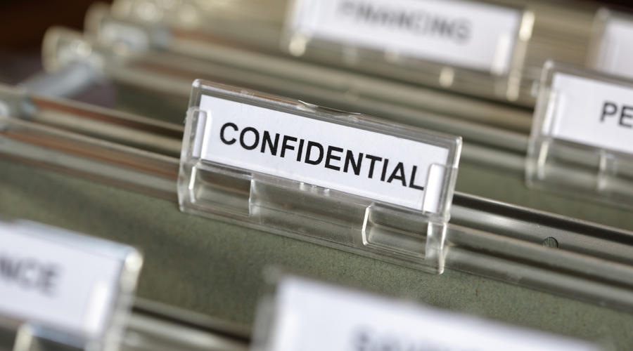 Cabinet drawer containing file marked confidential.